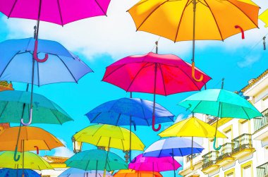 Renkli şemsiyeler kentsel sokak dekorasyon. Renkli şemsiye üzerinde mavi gökyüzü, suluboya asılı