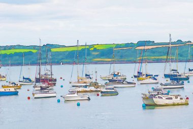 suluboya resim tasvir eden yat ve tekne resimde küçük bir koyda demirlemiş