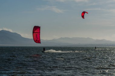 La Manga, Ispanya-4 Mart 2019 aktif spor pratiği yapan Insanlar, rüzgarlı bir koyda güç uçurtma kullanarak dalga sürme