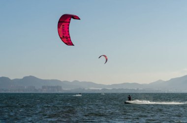 La Manga, Ispanya-4 Mart 2019 aktif spor pratiği yapan Insanlar, rüzgarlı bir koyda güç uçurtma kullanarak dalga sürme
