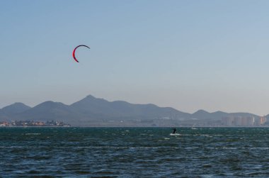 La Manga, Ispanya-4 Mart 2019 aktif spor pratiği yapan Insanlar, rüzgarlı bir koyda güç uçurtma kullanarak dalga sürme
