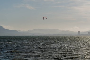 La Manga, Ispanya-4 Mart 2019 aktif spor pratiği yapan Insanlar, rüzgarlı bir koyda güç uçurtma kullanarak dalga sürme