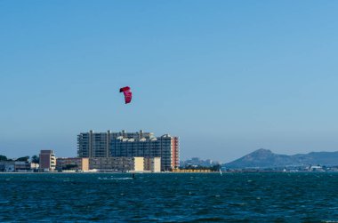 La Manga, Ispanya-4 Mart 2019 aktif spor pratiği yapan Insanlar, rüzgarlı bir koyda güç uçurtma kullanarak dalga sürme