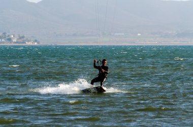 La Manga, Ispanya-4 Mart 2019 aktif spor pratiği yapan Insanlar, rüzgarlı bir koyda güç uçurtma kullanarak dalga sürme