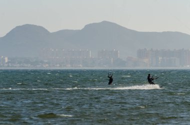 La Manga, Ispanya-4 Mart 2019 aktif spor pratiği yapan Insanlar, rüzgarlı bir koyda güç uçurtma kullanarak dalga sürme