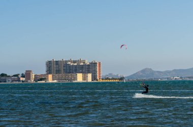 La Manga, Ispanya-4 Mart 2019 aktif spor pratiği yapan Insanlar, rüzgarlı bir koyda güç uçurtma kullanarak dalga sürme