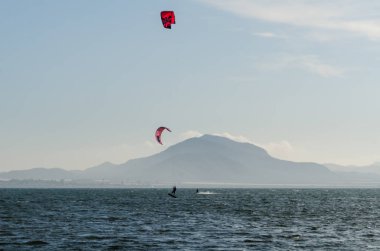 La Manga, Ispanya-4 Mart 2019 aktif spor pratiği yapan Insanlar, rüzgarlı bir koyda güç uçurtma kullanarak dalga sürme