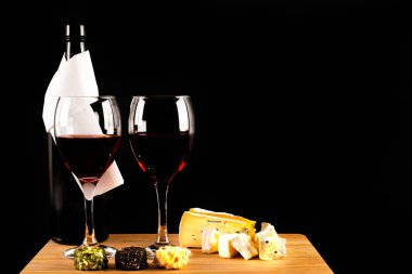 Kırmızı şarap ve ahşap bir tahta üzerinde farklı peynir seti, delicio