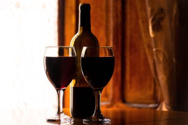 Bir şişe şarap ile bir şarap kadehinde kırmızı şarap, bir kutlama