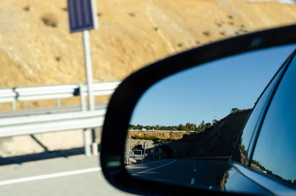 view in the car mirror on fast road in the Spain, beautiful land