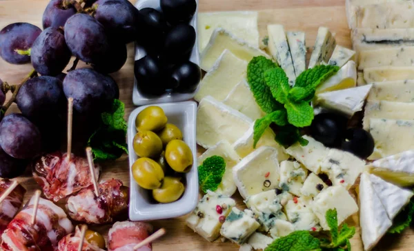 Jogo de queijos diferentes em uma tábua de madeira, placa de queijo, delici — Fotografia de Stock