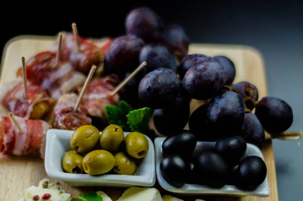 Azeitonas verdes servidas com uma variedade de queijos e lanches, delici — Fotografia de Stock
