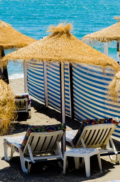 Bella spiaggia sabbiosa con ombrelloni di palma e mare blu — Foto Stock
