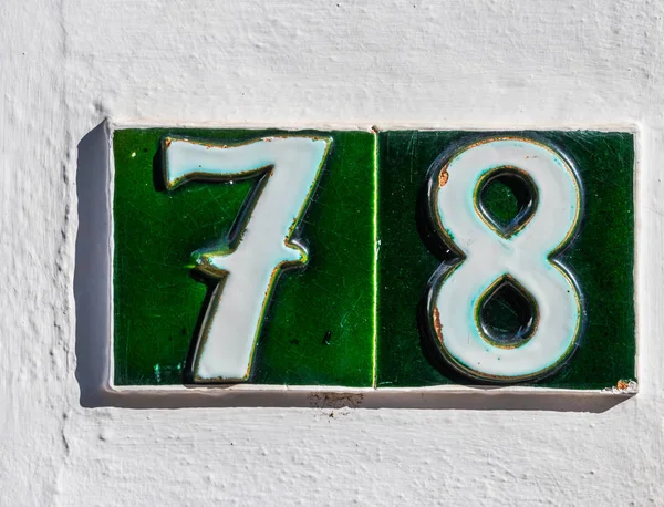 Decorative ceramic house number 78 tile on the wall, characteris