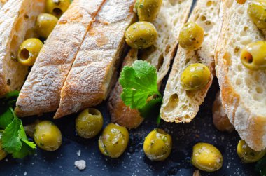 Zeytinle doldurulmuş baget, taze yeşil zeytin ve pa ile kesilmiş