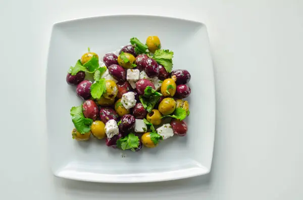 Ensalada griega fresca basada en aceitunas verdes y negras con trozos de —  Fotos de Stock