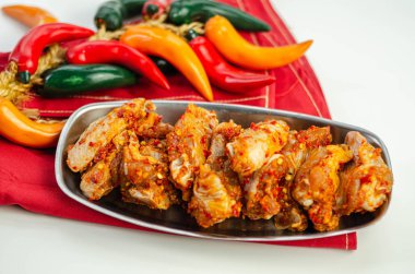 Sirracha salamurasında çiğ ve taze tavuk kanadı.