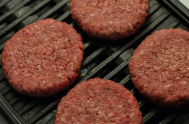 Baharatlı sığır burger, bir tutam tuz ve ızgarada karabiber.