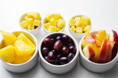 Çeşitli meyveler, ananas, elma, olgun çedar peynirli üzümler, sağlıklı atıştırmalıklar.