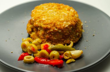 Morina ve karides kırmızı Tayland usulü balık keki turşulu zeytin, turşu, sarımsak ve kırmızı biber ile servis edilir.