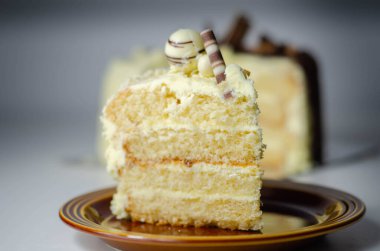 Bir parça katmanlı beyaz kremalı pasta, şekerleme süslemeleri, kutlama için tatlı.