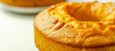 Beyaz arka planda süslenmiş taze madeira yüzük ekmek keki, geleneksel pasta.