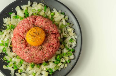Biftek tartar, çiğ yumurta sarısı ve soğanlı soğan, aperatif.