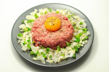 Biftek tartar, çiğ yumurta sarısı ve soğanlı soğan, aperatif.