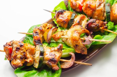 Tavuk, kabak, mantar, biber ve soğanlı ızgara şiş. Buzdağı salatasında servis ediliyor. Parti yemeği.