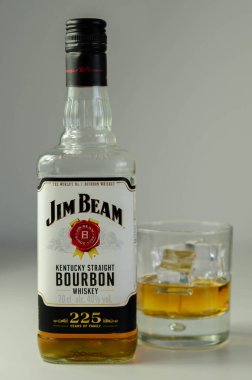 LONDON, UNITED KINGDOM - 04 Ağustos 2020 Viski bardağında sek viski ve Jim Beam ailesinin 225 yıllık anısına bir şişe