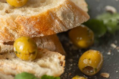 Taze baget ve sağlıklı yiyeceklerle servis edilen turşulu İspanyol yeşil zeytinleri.