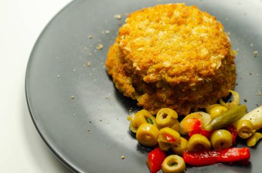 Morina ve karides kırmızı Tayland usulü balık keki turşulu zeytin, turşu, sarımsak ve kırmızı biber ile servis edilir.