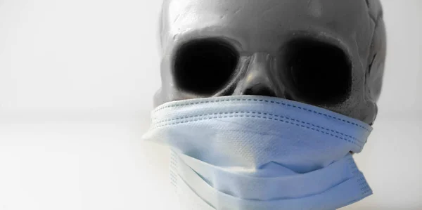 医療用マスクを身に着けている恐ろしい人間の頭蓋骨 ウイルスの流行からの死の象徴的な描写 コロナウイルス — ストック写真