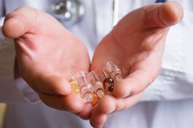 Doktor, tıp ile şeffaf ampul avuç içi tutar. Konsept fotoğraf öneriler veya onay kutularını seçerek tedavi çeşitli hastalıklar veya farmakolojik çalışmalar ilaçların etkinliğini göstermek için