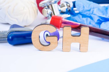 Gh kısaltma veya kısaltma ön planda laboratuvar bilimsel veya tıbbi uygulama anlamı büyüme hormonu veya somatotropin, beyin, nörolojik çekiç laboratuvar test tüpleri stetoskop model ile