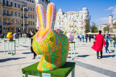 Renkli arka planda meydanında bir bukalemun gibi eski kılığında Paskalya tavşan figürü ev sahipliği yapmaktadır. Güzel Paskalya dekorasyon sanat