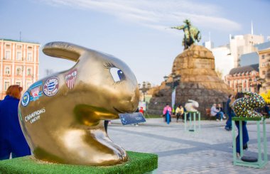 Paskalya tavşanı rakam altın renkte bilet içinde onun ağız ile Şampiyonlar Ligi Finali çerçevede Bohdan Khmelnitsky anıt için Kiev sembolü olarak