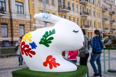 Paskalya tavşanı beyaz insanlar dikkate alınarak arka plan üzerinde kapalı gözler ile kırmızı, mavi ve yeşil yapraklarla bul. Güzel Paskalya dekorasyon sanat. Kiev (Kiev), Ukrayna, Nisan 2018