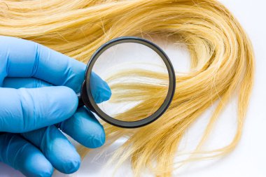 Doktor dermatolog veya trichologist sağlık hasta saç beyaz arka plan üzerinde büyüteç ile tanılar. Saç, split biter, zayıf, saç düşen bölünemez hastalıkların konsept fotoğraf 