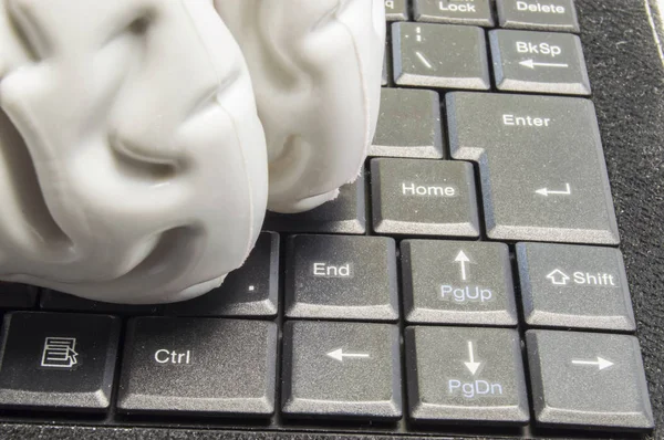 Anatomical model of the human brain lies on a black computer keyboard picture close up. Concept photo of brain games, computer games and the influence on mental activity