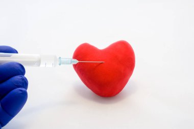 Kalp veya kalp-damar hastalıkları tedavi kavramı fotoğraf içine enjeksiyon. Doktor eldiven, ilaç şırınga giymiş elinde tutan ve enjeksiyon şekil kart kırmızı kalp içinde yapmak hazırlanıyor
