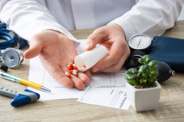 Doktorlar randevu hekim konteyner odaklanılan elden içine yandan ilaçlar ile boşaltılmış hasta kapsül gösterir. Sahne jenerik reçeteli veya reçetesiz ilaçlar doktor tarafından ziyaret