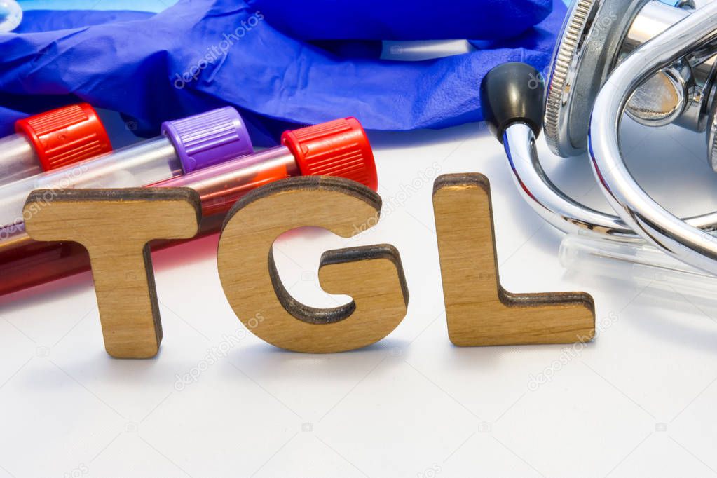 TGL abbreviature mean triglyceride simple blood test  with lab tubes with blood and stethoscope. Using acronym TGL in laboratory clinical diagnosis, measure the level of triglycerides in blood