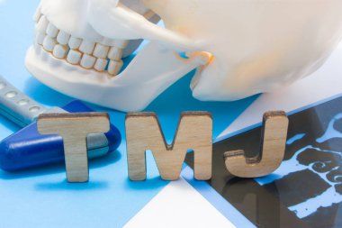 Temporomandibuler eklemin TME tıbbi kısaltması. TME harfleri alt çene, nörolojik çekiç ve ilerlemenin insan kafatası çevrili. Anatomi, patoloji temporomandibular eklemin kavramı