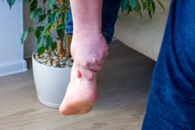Kişi şiddetli ağrı nedeniyle aşil tendonu veya topuk kordonu el ile yakaladı. Boşluk, rüptür, burkulma, tendonit, tendonoz gibi aşil tendonların belirti ve hastalık ve yaralanması kavram fotoğrafı 