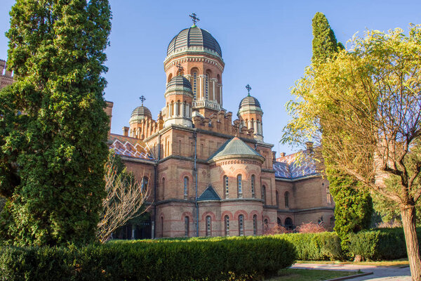 Side view of building of Church of Three Saints in greenery in territory of Chernivtsi National Public University  