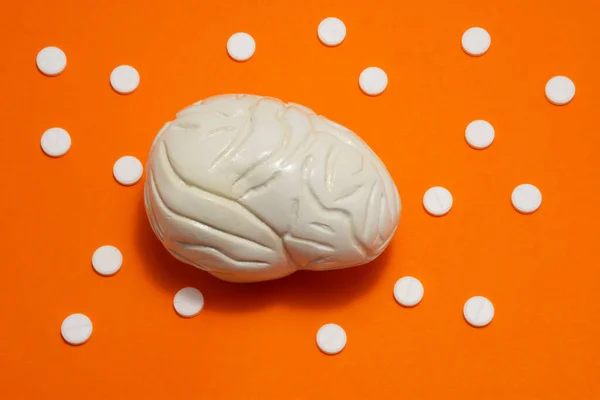 Modelo Anatómico Del Cerebro Está Sobre Fondo Naranja Rodeado Píldoras —  Fotos de Stock