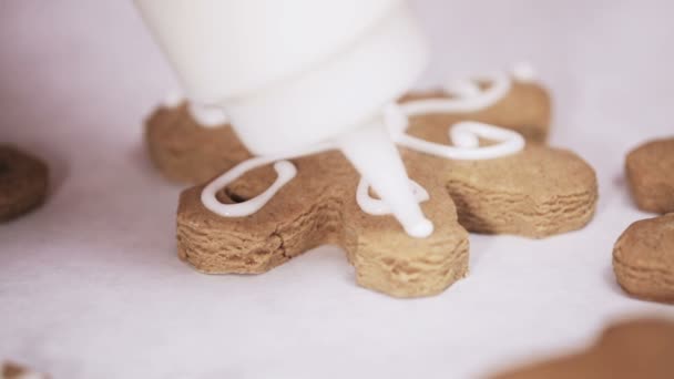クリスマスのため高貴なアイシングで伝統的なジンジャーブレッドのクッキーを飾ること — ストック動画