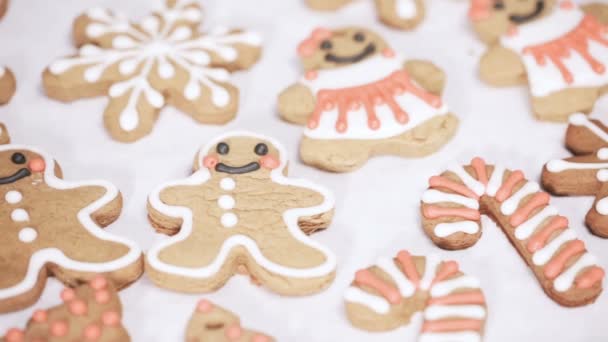 クリスマスのため高貴なアイシングで伝統的なジンジャーブレッドのクッキーを飾ること — ストック動画
