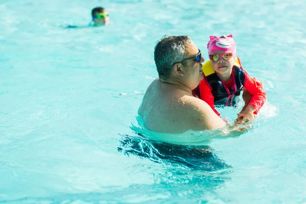 父亲和女儿在室外游泳池游泳 — 图库照片